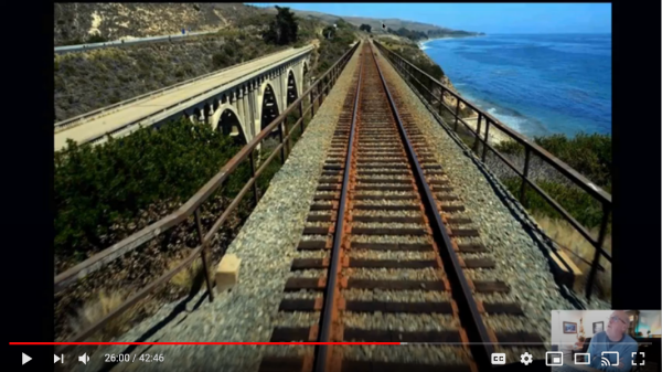 photo of tracks on bridge with ocean